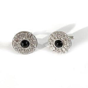 A pair of cufflinks with a ring of celtic symbols surrounding a 10mm black onyx cabachon